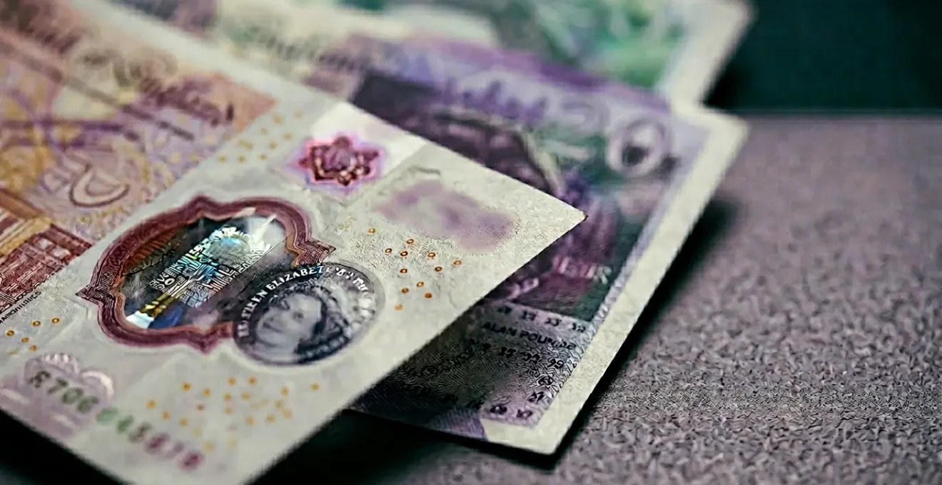 Close-up photograph of British pound sterling banknotes with natural shallow depth of field representing cash savings and financial opportunity